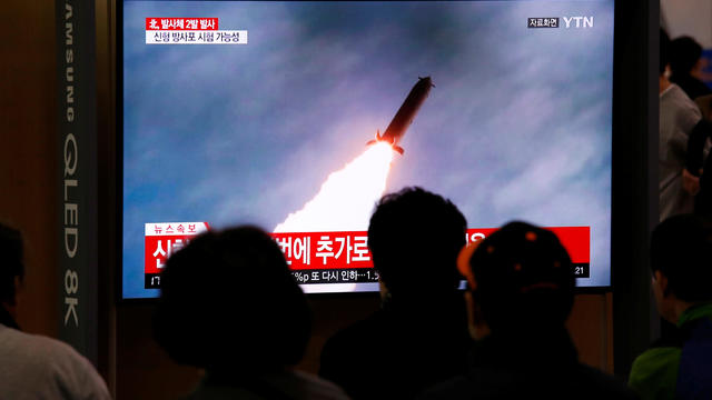 People watch a TV broadcast showing a file footage for a news report on North Korea firing two projectiles, possibly missiles, into the sea, in Seoul 