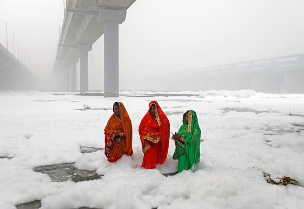 Hindu women worship the Sun god in the polluted waters of the river Yamuna during the Hindu religious festival of Chatth Puja in New Delhi 