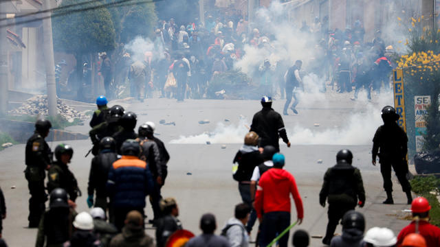 Supporters of Bolivian President Evo Morales and opposition supporters clash during a protest after Morales announced his resignation on Sunday, in La Paz 