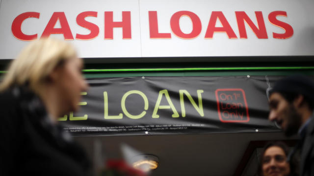 Pedestrians pass by a lending shop in northeast London 