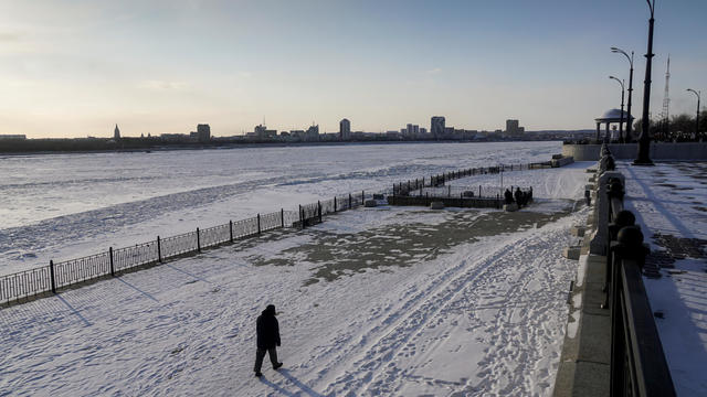 FILE PHOTO: A man walks along an embankment of the Amur river, with Chinese town of Heihe seen in the background, in the far-eastern town of Blagoveshchensk 