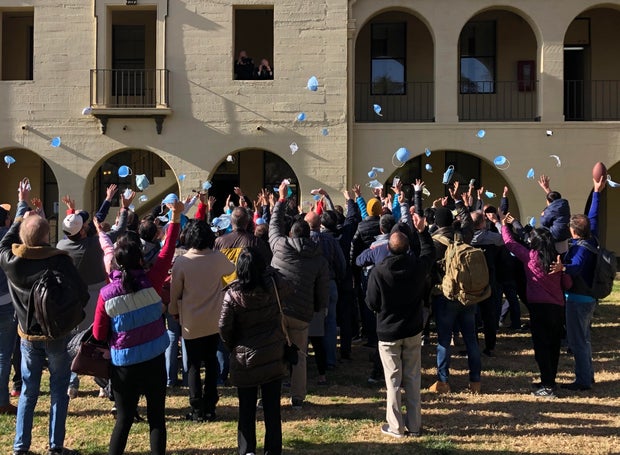 People evacuated from the epicenter of the coronavirus outbreak in China celebrate the end of their quarantine at March Air Reserve Base in Moreno Valley, California, on February 11, 2020.