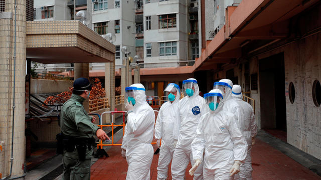 Police in protective gear wait to evacuate residents from a public housing building, following the outbreak of the novel coronavirus, in Hong Kong 