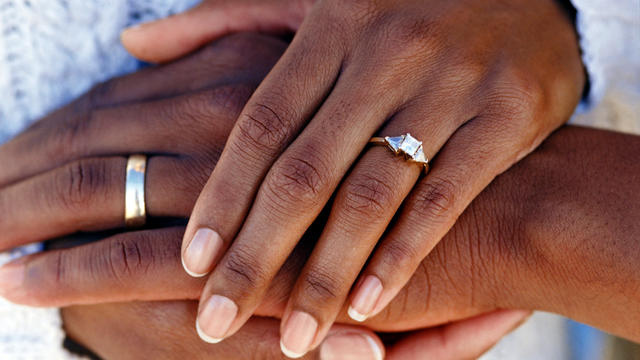 Hands of married couple wearing wedding rings 