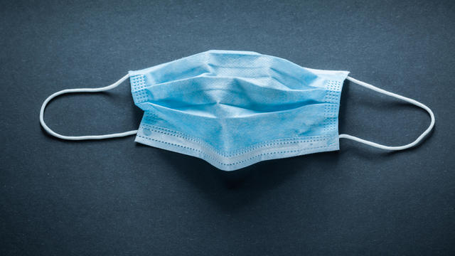 Disposable surgical mask on black background 