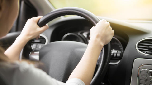 Close-up of female hands on the steering wheel 