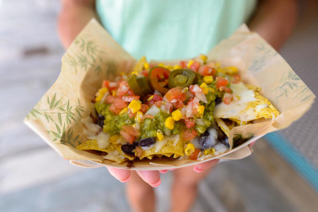 Close Up of Woman Hands Holding Mexican Nachos 