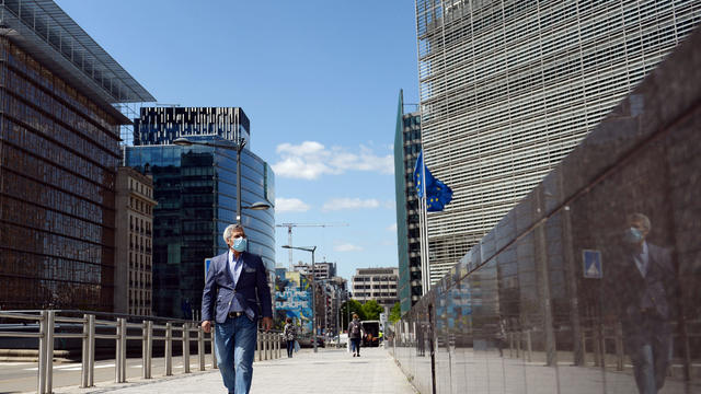 A man wearing a face mask walks past the European Commission headquarters as the spread of coronavirus disease (COVID-19) continues in Brussels 