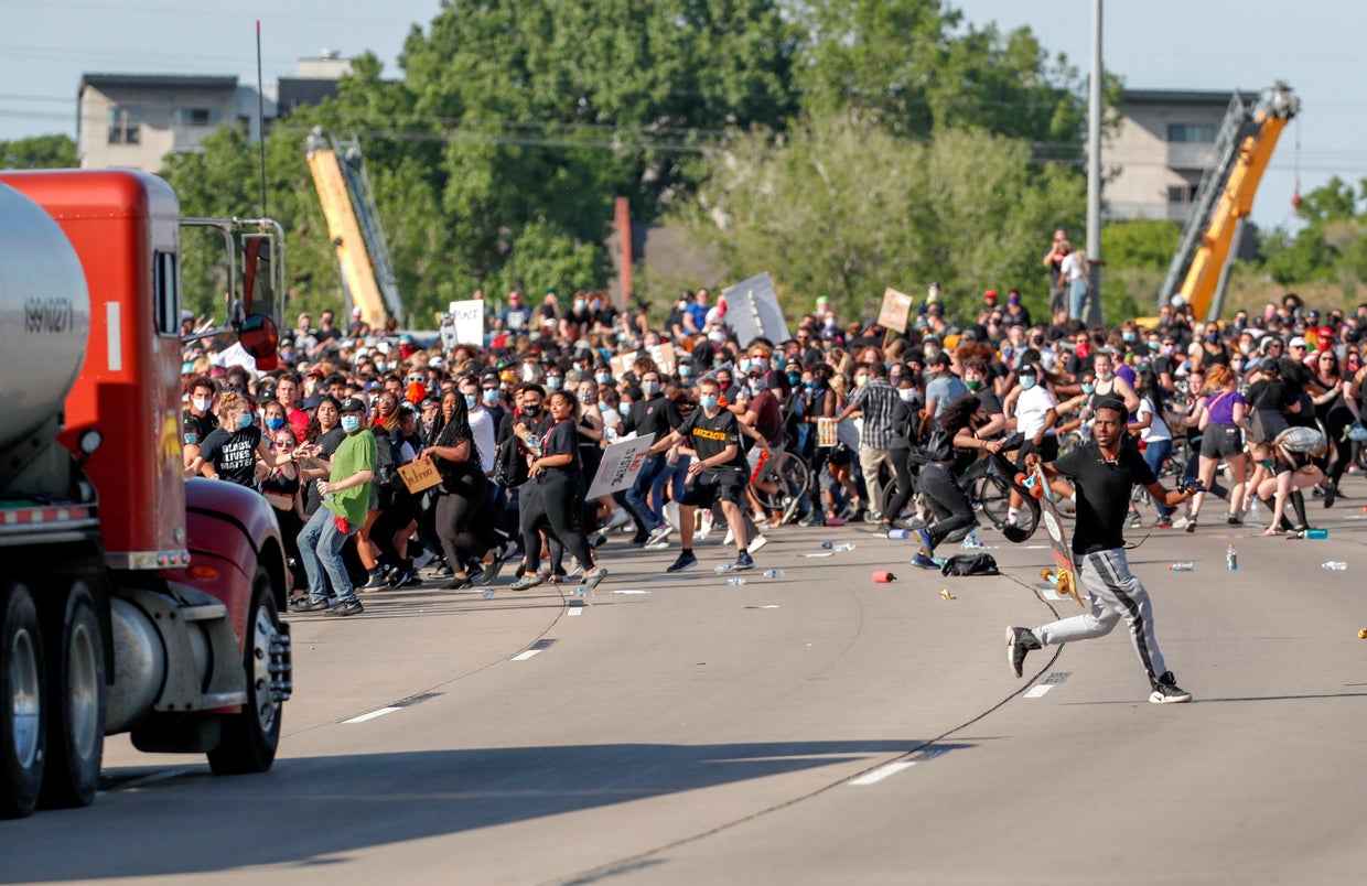 Truck driver arrested after appearing to drive through protesters on ...