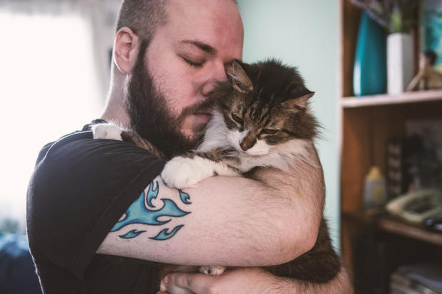 A white bearded man holding his cat 