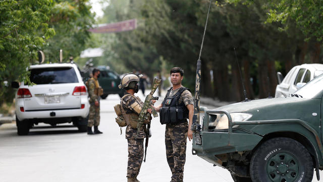 Afghan security forces stand guard near the site of an attack in Kabul, Afghanistan 