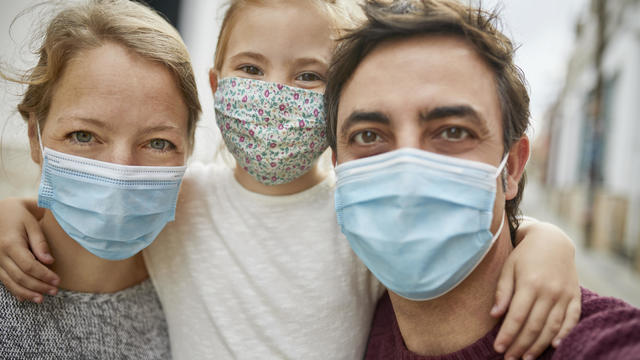 Optimistic Family Selfie during Coronavirus Emergency. All Wearing Protective Face Mask 