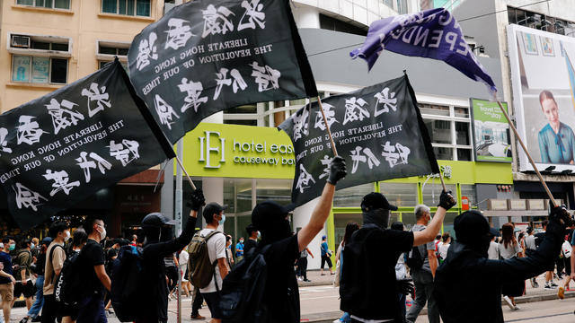 Pro-democracy activists Ivan Lam, Joshua Wong and Agnes Chow arrive at the West Kowloon Magistrates' Courts to face charges related to illegal assembly stemming from 2019, in Hong Kong 