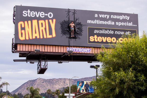 Steve-O Duct-Tapes Himself To Billboard In Promotion Of His New Special "Gnarly" 