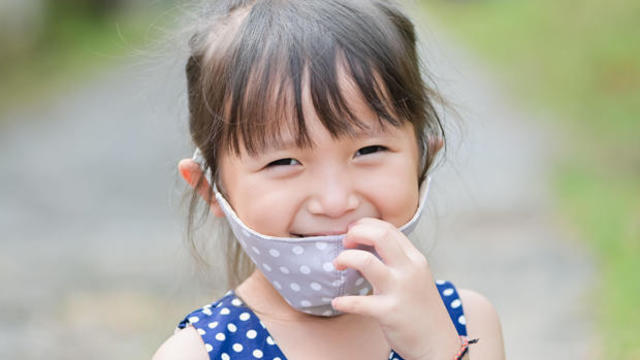 Little girl has fabric mask protect herself from Coronavirus COVID-19,hand stop sign when child leave the house,,child with a mask on her nose for 