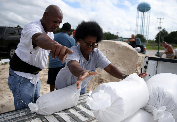 Sam Dorsey helps Dianne Fredrick load a sandbag in the back of her truck as Tropical Storm Sally approaches in Bay St. Louis 
