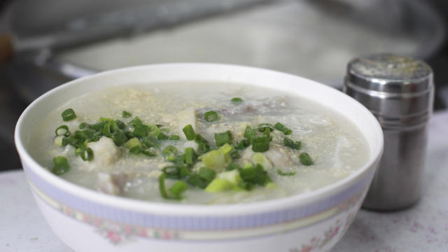 This image shows a signature congee by Congee and Noodies shop owner " Sai Chu ", is seen a congee, chinese rice porridge in a bowl,  street food stall at Lung Mun Oasis in Tuen Mun.  25MAY16   SCMP / May Tse 