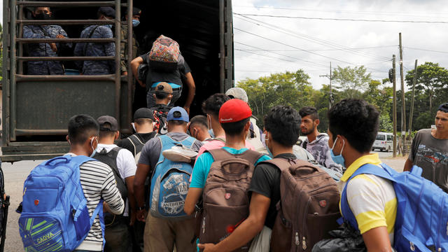 Honduran migrants trying to reach the U.S. get inside a truck escorted by the Guatemalan soldiers to send them back to Honduras, in Morales 