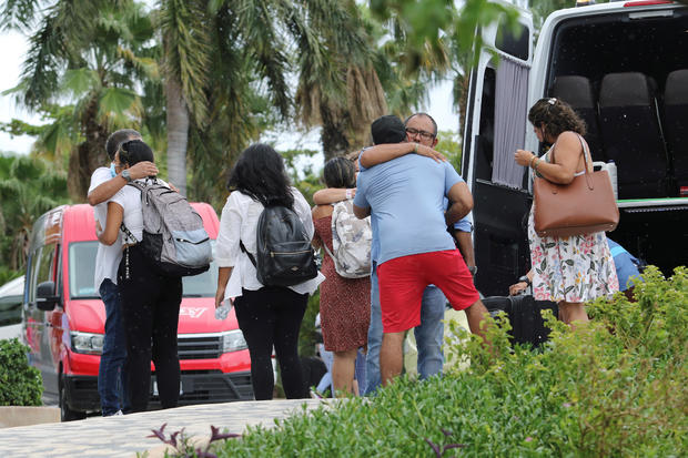 Tourists embrace as they leave a hotel ahead of the arrival of Hurricane Delta, in Cancun 