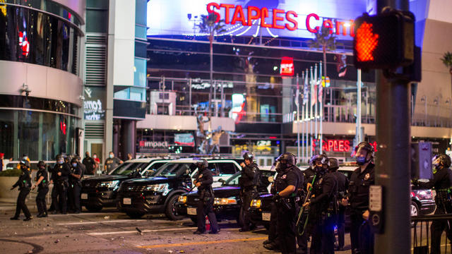 Police try to control a crowd on the street outside the Staples Center as Los Angeles Lakers fans celebrate their team winning the 2020 NBA Championship against Miami Heat 