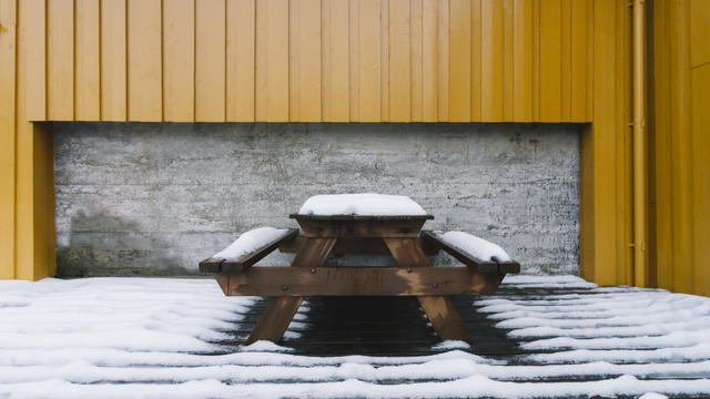 Snow-covered picnic table in Nusfjord, Lofoten Islands, Norway 