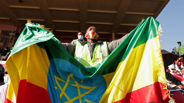 A volunteer holds an Ethiopian flag during a blood donation ceremony for the injured members of Ethiopia's National Defense Forces fighting against Tigray's special forces on the border between Amhara and Tigray, at the stadium in Addis Ababa, Ethiopia, November 12, 2020. 