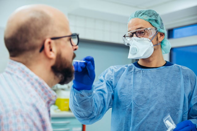 Doctor in hospital taking a swab from patient's mouth