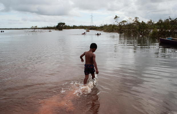 A child plays on a road flooded by the Wawa Boom river due to heavy rain caused by Hurricane Iota as it passed through the Caribbean coast in Bilwi 