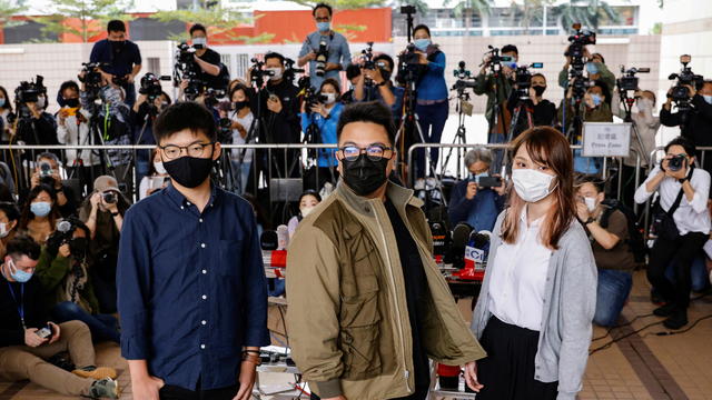 Pro-democracy activists Ivan Lam, Joshua Wong and Agnes Chow arrive at the West Kowloon Magistrates' Courts to face charges related to illegal assembly stemming from 2019, in Hong Kong 