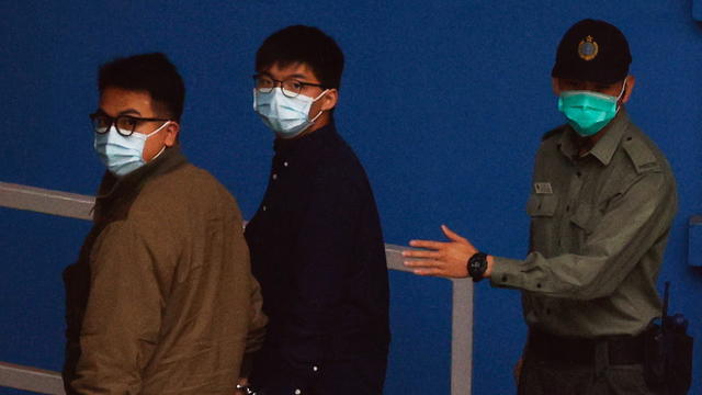 Pro-democracy activists Ivan Lam and Joshua Wong arrive at Lai Chi Kok Reception Centre by prison van after pleading guilty to charges of organising and inciting an unauthorised assembly near the police headquarters during last year's anti-government prot 