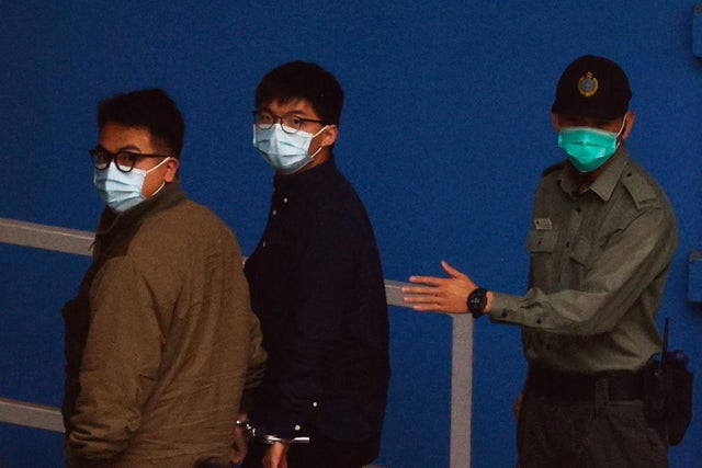 Pro-democracy activists Ivan Lam and Joshua Wong arrive at Lai Chi Kok Reception Centre by prison van after pleading guilty to charges of organising and inciting an unauthorised assembly near the police headquarters during last year's anti-government prot 