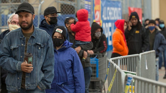 Masked customers line up outside a Walmart