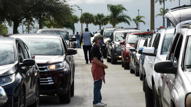 Volunteers direct traffic as residents line up in their cars 