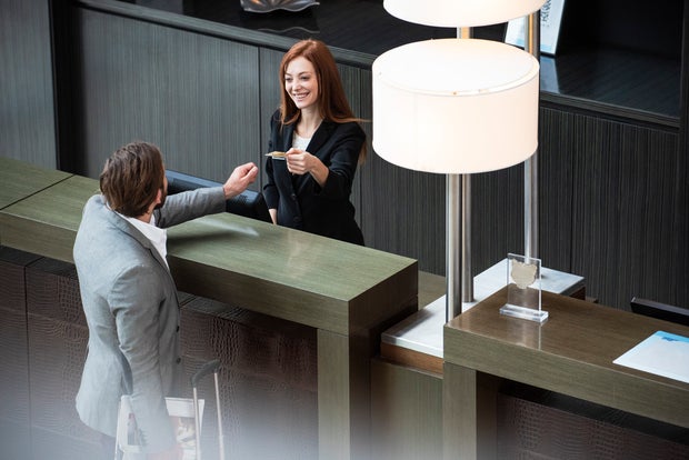 Female receptionist giving credit card to businessman 