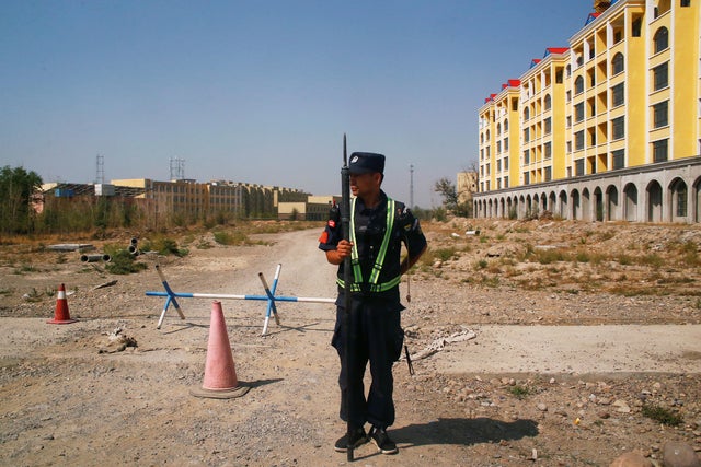 FILE PHOTO: A Chinese police officer takes his position by the road near what is officially called a vocational education centre in Yining 