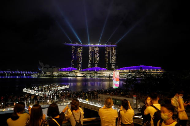 People watch a light show, as the traditional New Year's Eve fireworks are cancelled due to the coronavirus disease (COVID-19) outbreak, at Marina Bay in Singapore 