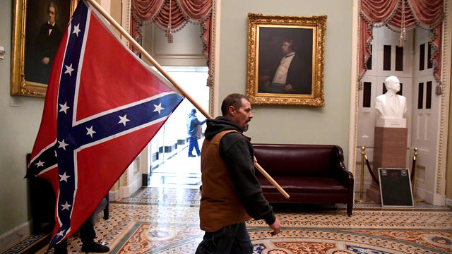 Trump supporter carries a Confederate flag in the U.S. Capitol 