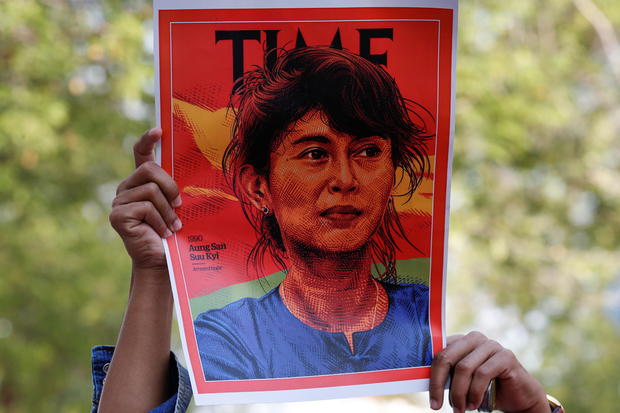 A person holds up a placard depicting Aung San Suu Kyi in Bangkok 