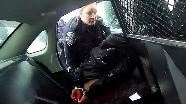 A Rochester police officer asks a handcuffed 9-year-old girl to get into a patrol car prior to the girl being sprayed with pepper spray in a still image from bodycam video taken in Rochester, New York, January 29, 2021. 