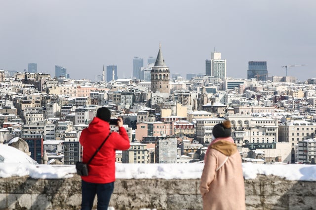 People seen taking photos in the snow-covered garden of the 