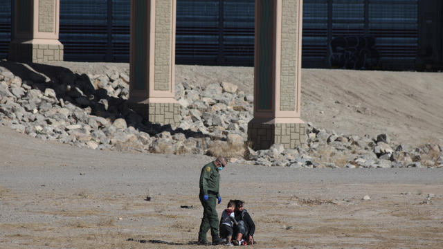 A Central American woman and her son cross the Rio Grande to 