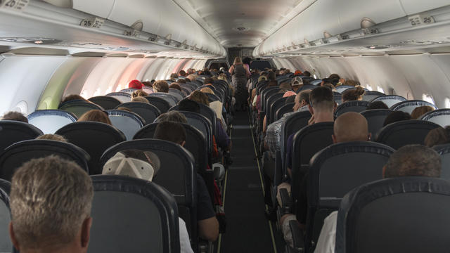 Rear View Of People Sitting In Airplane 