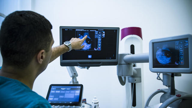 Doctor examining breasts with mammogram 