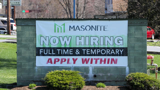 A now hiring sign is seen outside of Masonite, a door and 