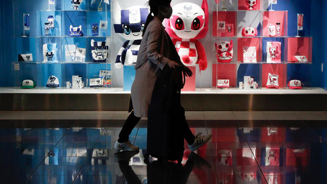 A shopper walks past the official shop of the Tokyo Olympics 