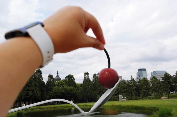 Optical Illusion Of Hand Holding Tip Of Cherry Sculpture On Spoon At Minneapolis Garden 