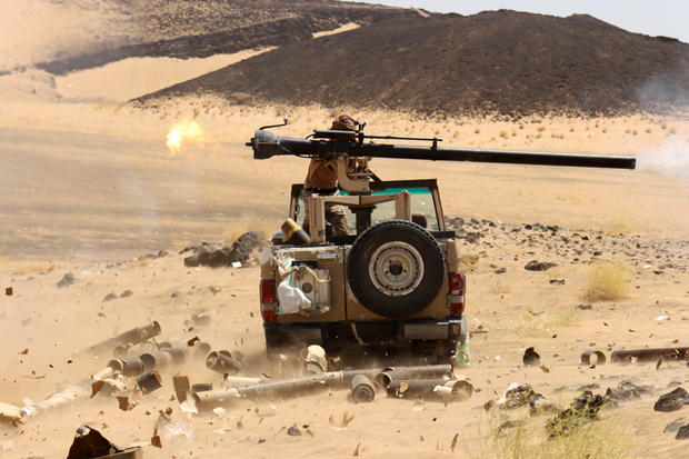 Yemeni government fighter fires a vehicle-mounted weapon at a frontline position during fighting against Houthi fighters in Marib 