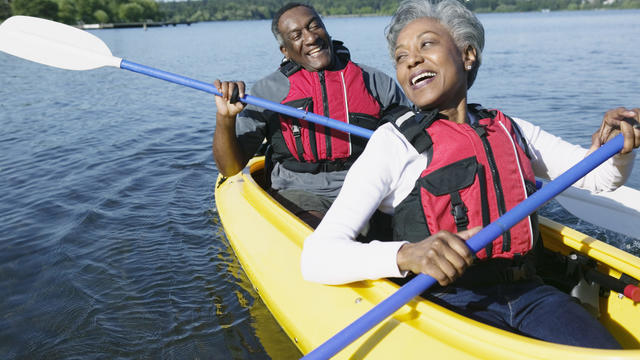 Elderly couple sitting together in a kayak on a lake 