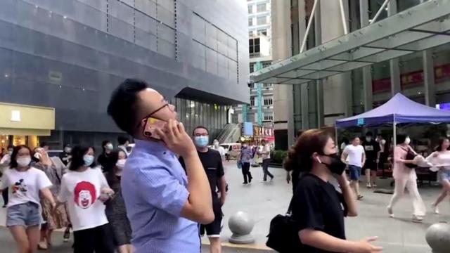 People gather outside the 73-storey SEG skyscraper in Shenzhen 