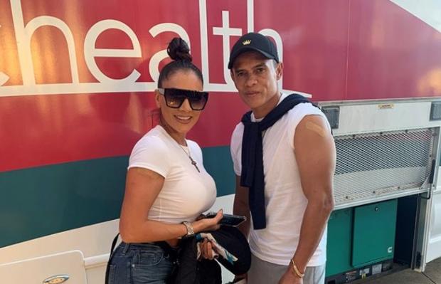 Yanessa Salas-Muñoz and Walter Centeno Corea pose outside the UCHealth vaccine bus Thursday at Empower Field at Mile High in Denver after receiving their shots. 